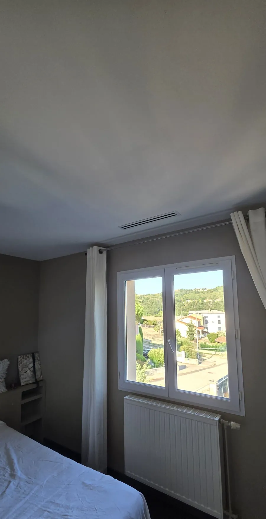 Radiateur de chauffage central posé sous la fenêtre d'une chambre rénovée
