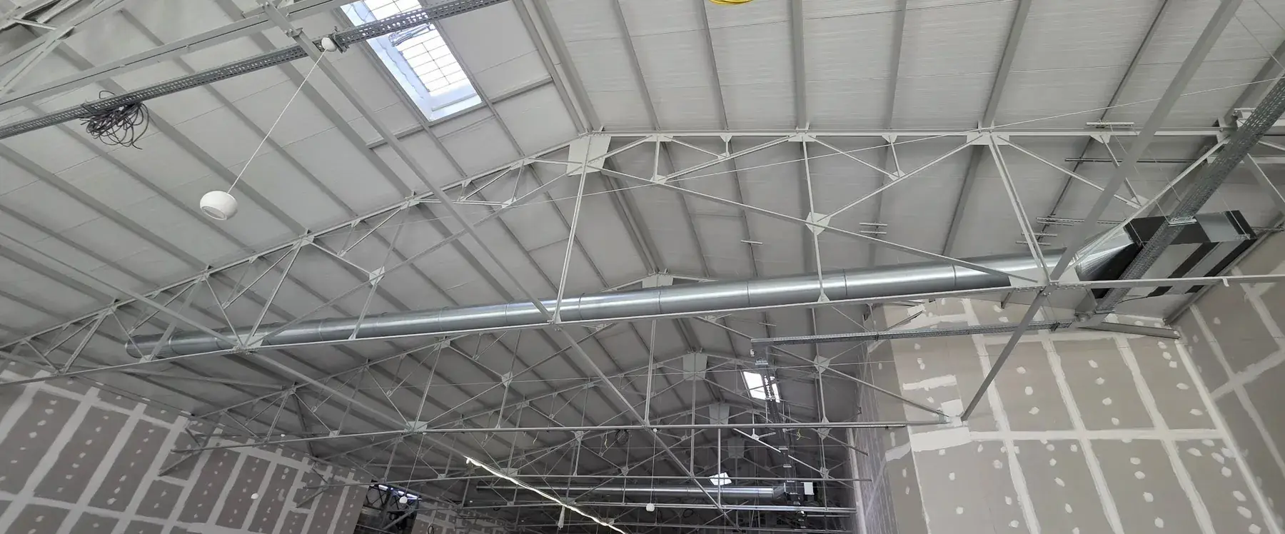 Réseau de gaines de ventilation dans un bâtiment industriel